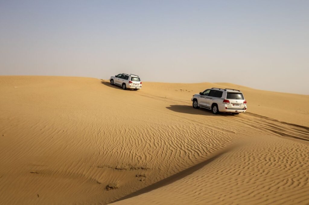 4x4 vehicles traversing sand dunes in Abu Dhabi, showcasing desert adventure and exploration.